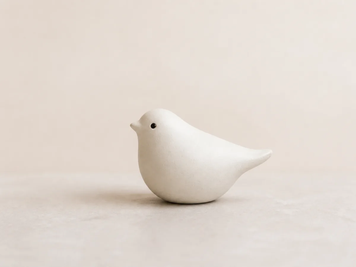 A matte white ceramic bird before a creative material transformation.